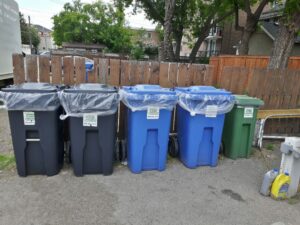 A row of garbage containers left by Green Planet Recycling Staff